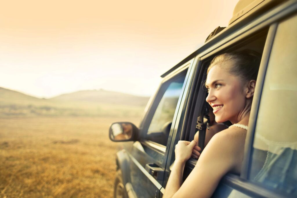 Smiling woman in an SUV driving with a Carnet Australia overseas