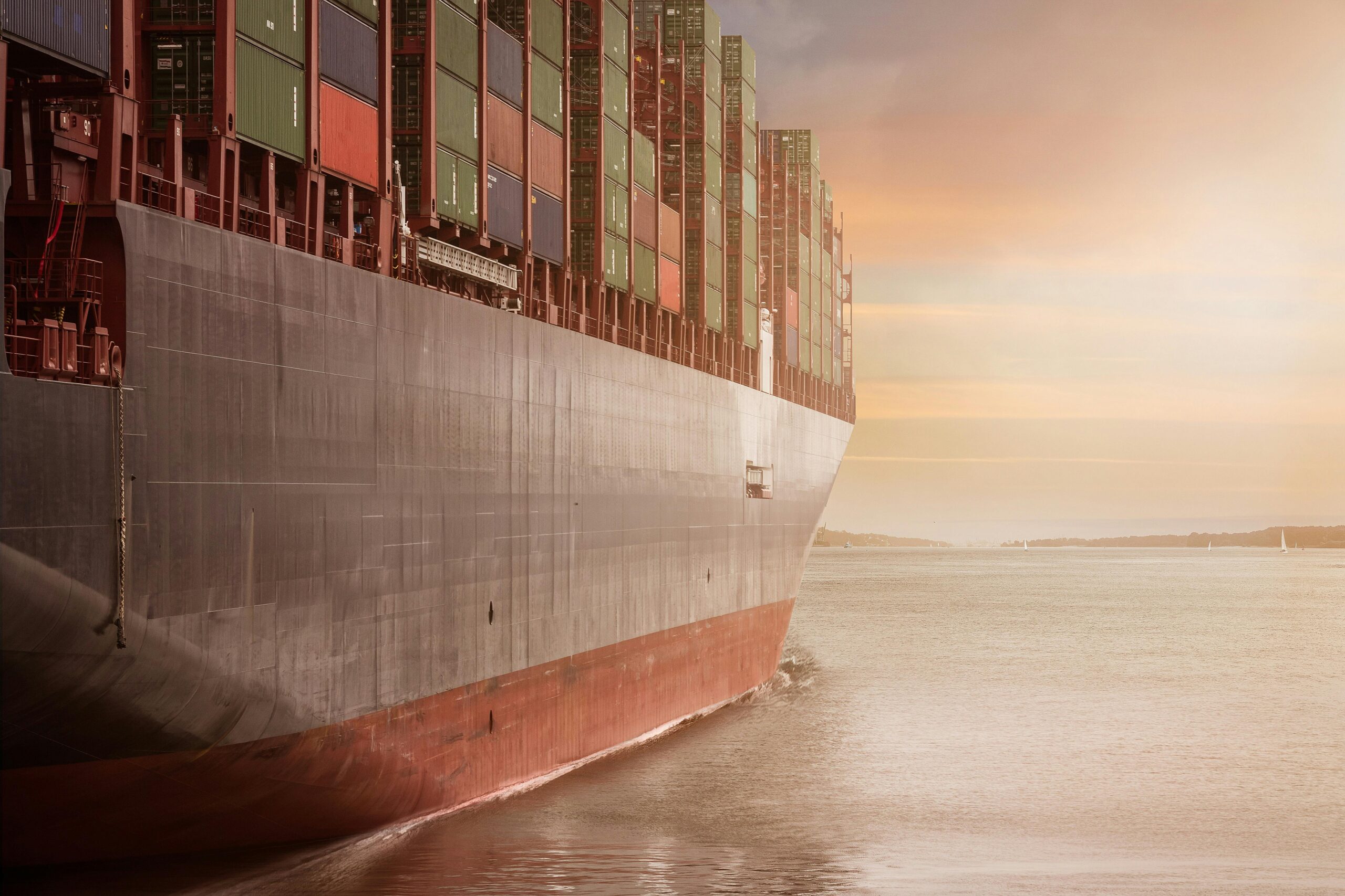 Sea freight services with loaded shipping containers departing port into the sunset - essential for freight forwarding US to Australia and international freight shipping overseas.