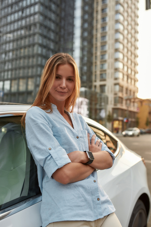 Woman with blue shirt leaning on import cars from japan to new zealand