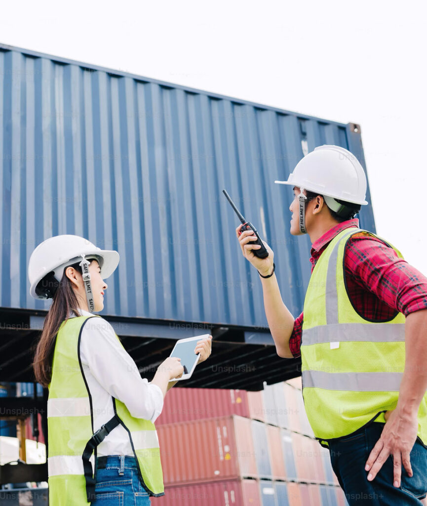 Freight forwarding services - Two works standing in front of shipping containers